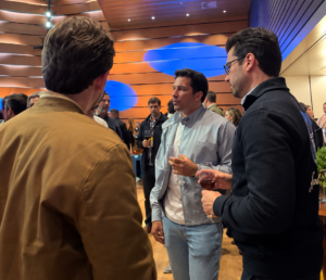 Três homens conversando sob luzes azuis